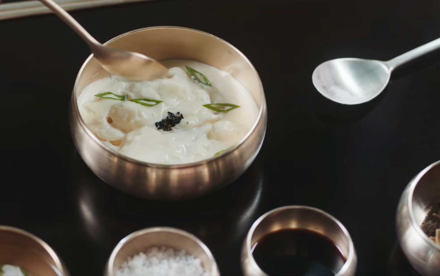 Platillo-Nº10-—-Restaurante-Joseon Dos lightsticks ARMY Bomb de BTS sostenidos en alto durante un concierto, con el escenario iluminado al fondo.