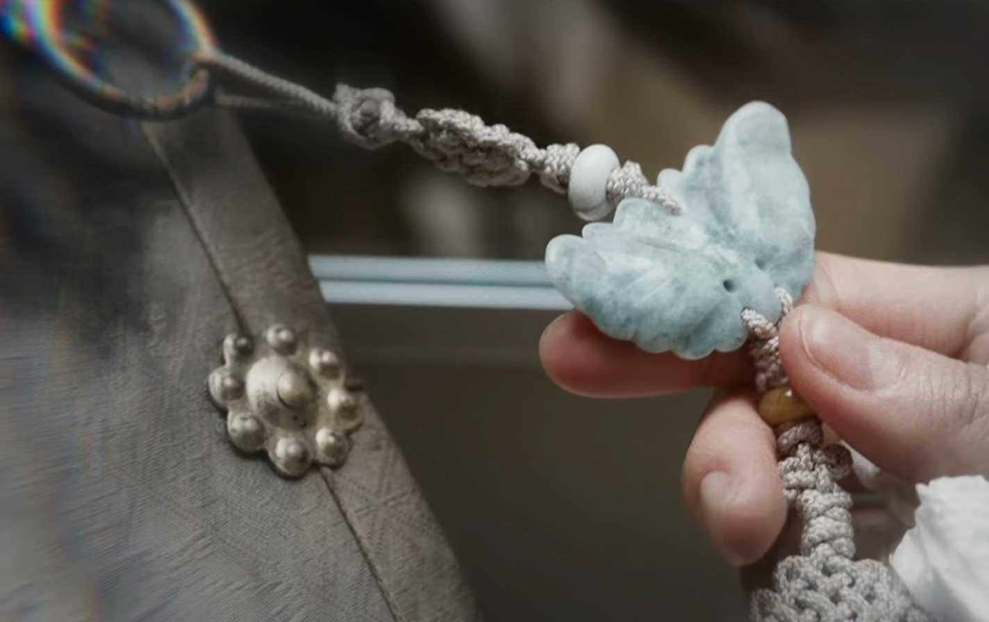 Platillo-Nº12-—-Hwanseban Dos lightsticks ARMY Bomb de BTS sostenidos en alto durante un concierto, con el escenario iluminado al fondo.