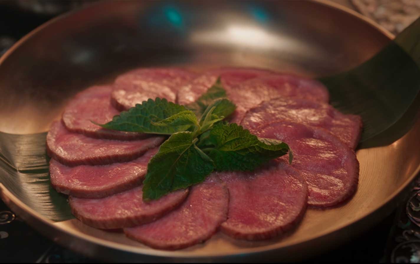 Platillo-Nº3-Alta-cocina-al-estilo-Joseon-3 Dos lightsticks ARMY Bomb de BTS sostenidos en alto durante un concierto, con el escenario iluminado al fondo.