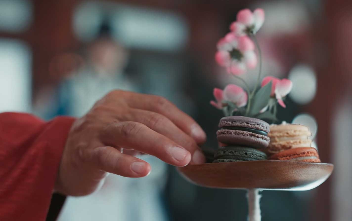 Platillo-Nº6-—-Macaron-de-sésamo-negro Dos lightsticks ARMY Bomb de BTS sostenidos en alto durante un concierto, con el escenario iluminado al fondo.