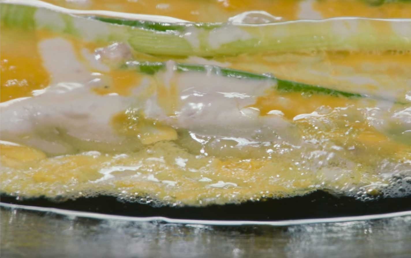 Platillo-Nº7-—-Pajeon-de-Dongnae-para-un-día-lluvioso Dos lightsticks ARMY Bomb de BTS sostenidos en alto durante un concierto, con el escenario iluminado al fondo.