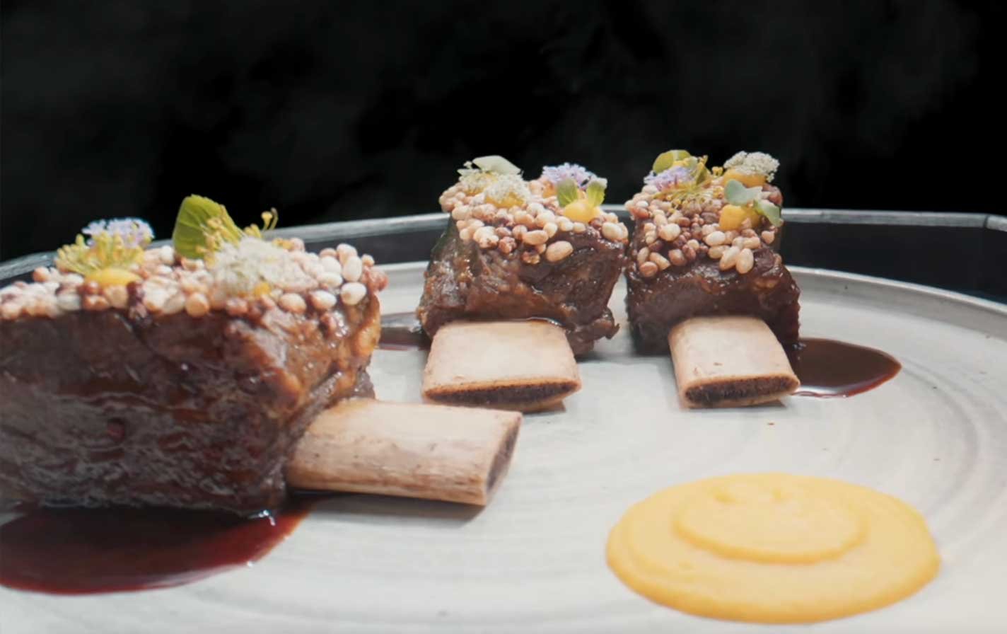 Platillo-Nº8-—-Bourguignon-de-res-al-vino-de-arroz Dos lightsticks ARMY Bomb de BTS sostenidos en alto durante un concierto, con el escenario iluminado al fondo.