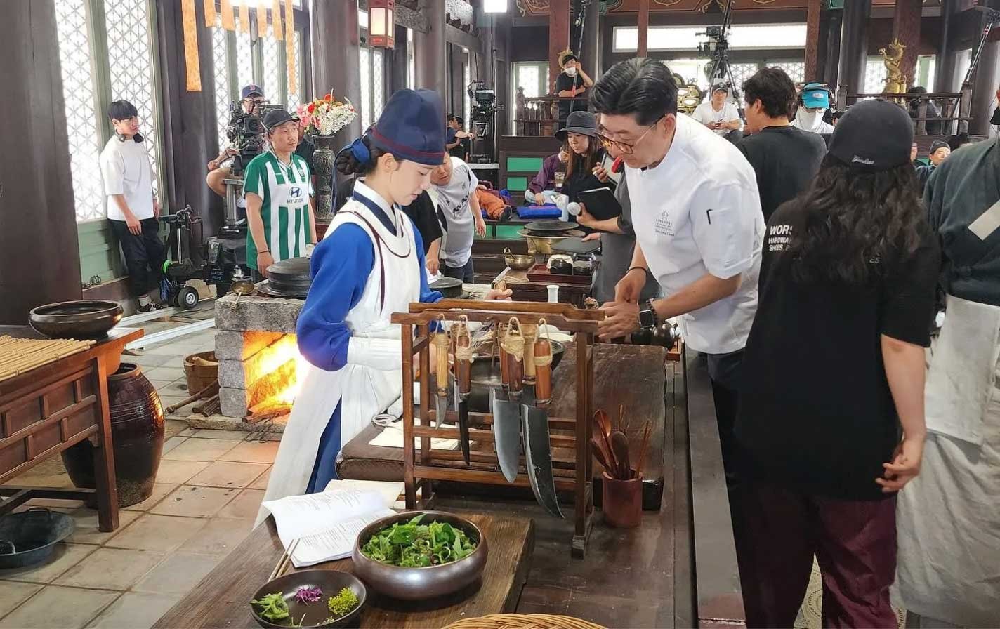 Yoon-ah-junto-al-chef-Shin-Jong-cheol-(director-culinario-de-la-serie). Fans occidentales con vestimentas temáticas y pancartas personalizadas antes de un concierto de TXT (ACT: PROMISE).